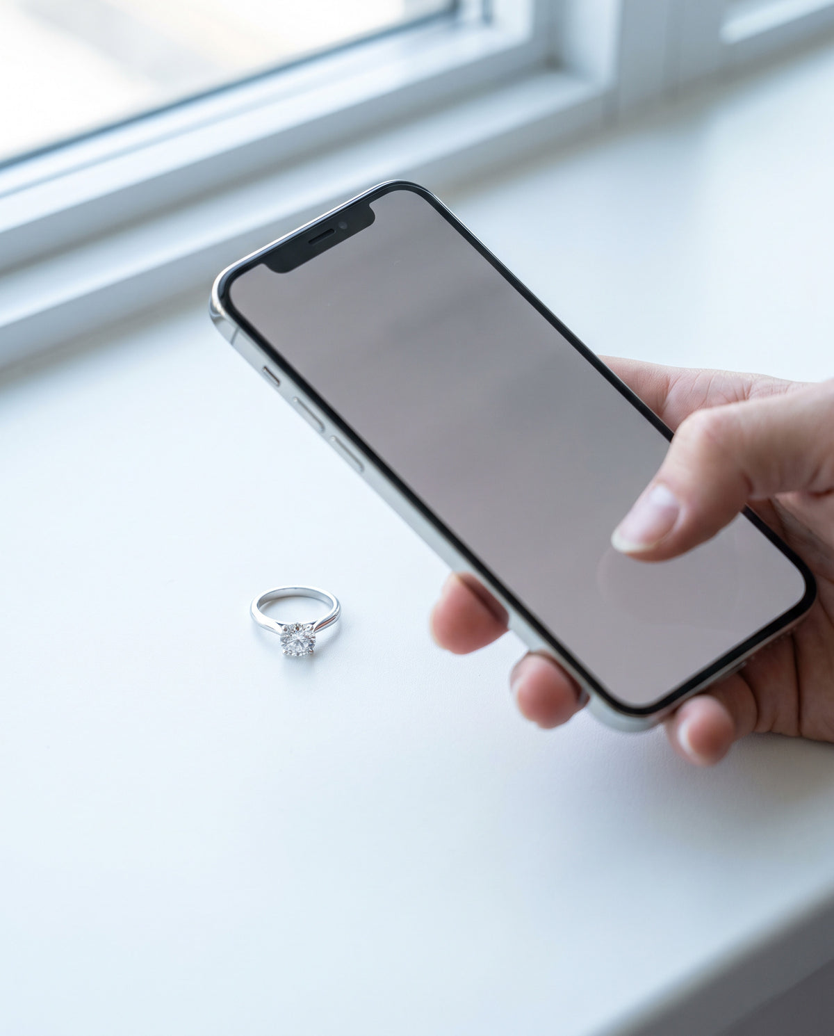 Phone photographing a diamond ring for an online claw check