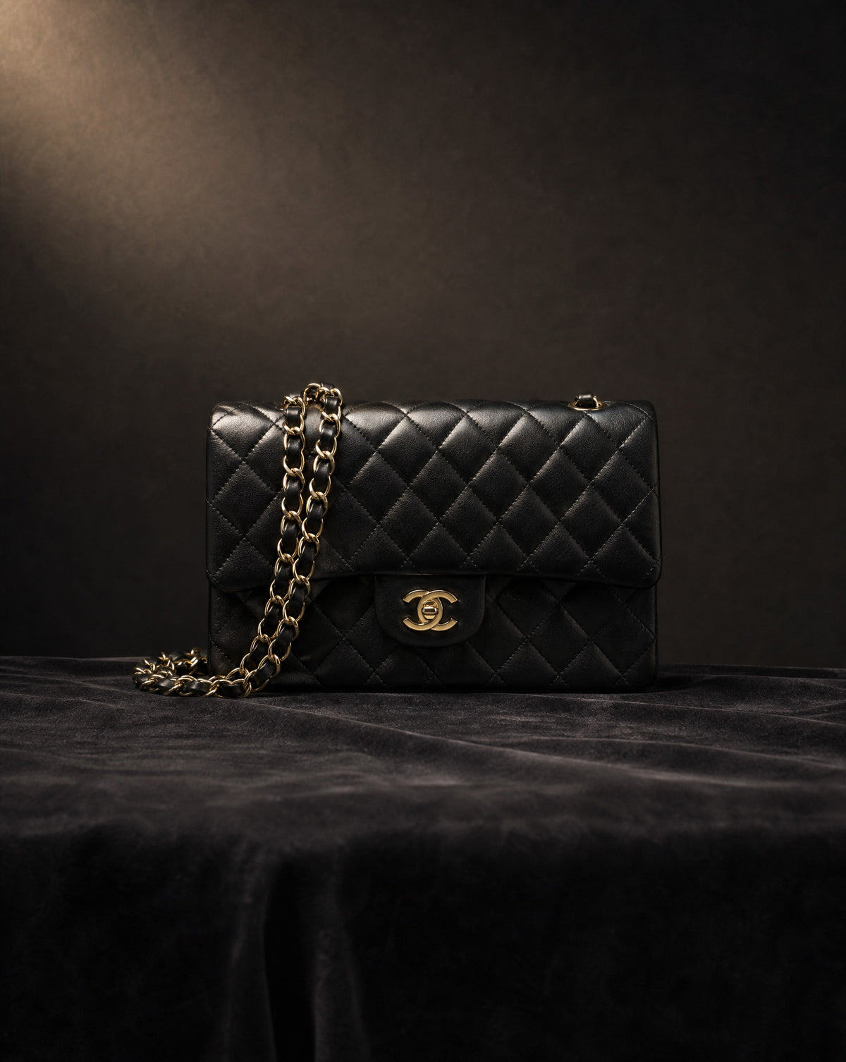Black quilted Chanel flap bag with gold chain, designer handbag valuation
