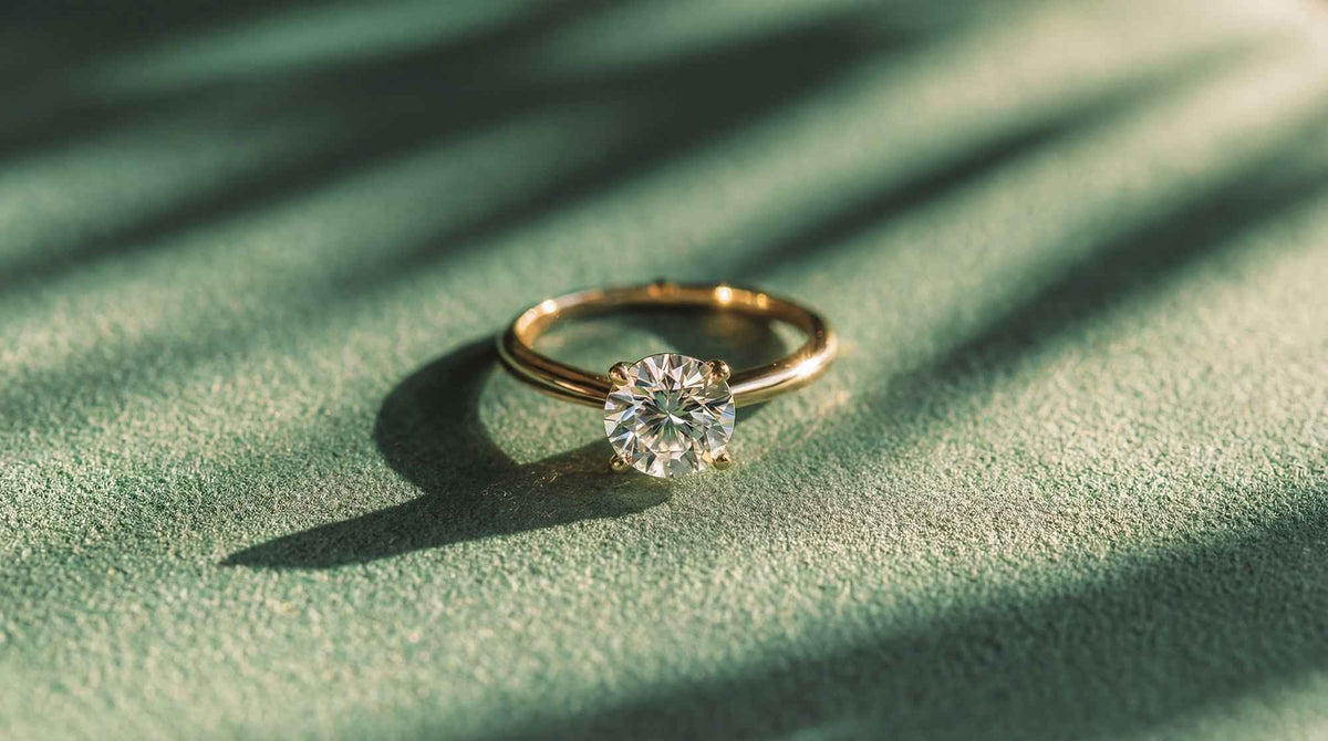 Gold diamond solitaire engagement ring on green velvet, professional jewellery valuation in Hatton Garden